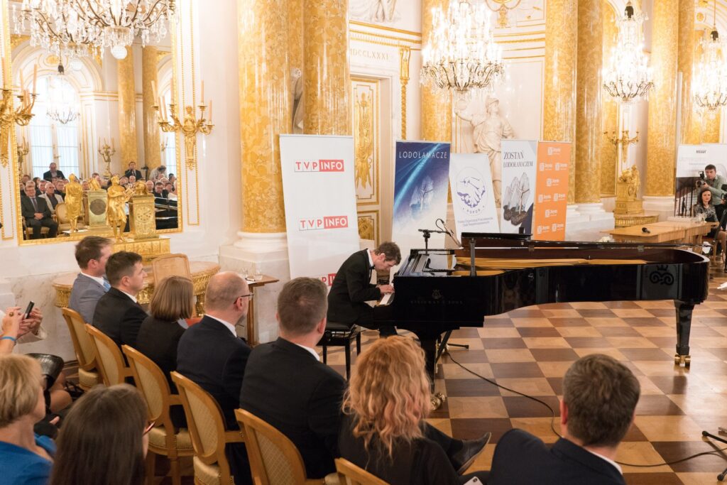Na zdjęciu uczestnicy gali Lodołamacze, a w centru, mężczyzna gający na fortepianie