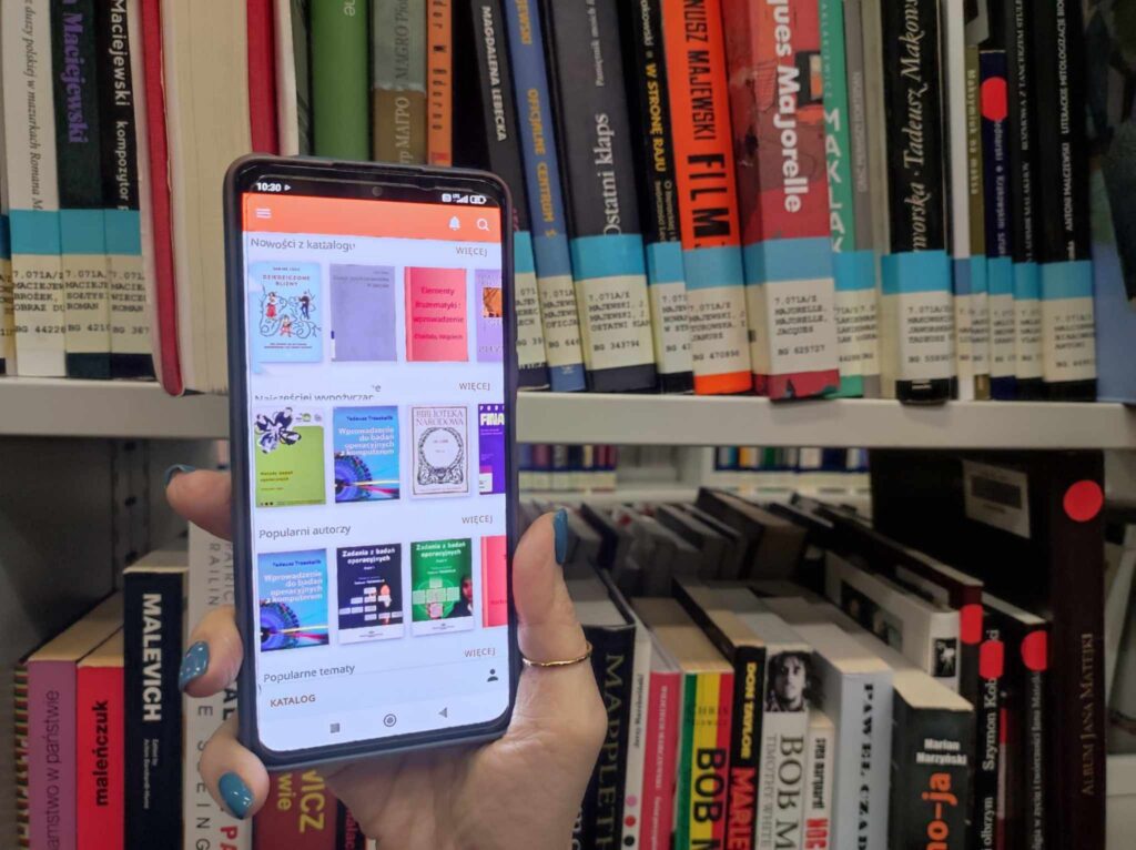 zdjęcie telefonu na tle półek z książkami