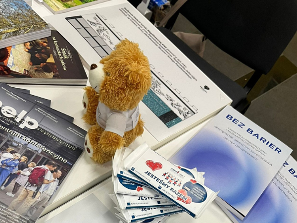 ulotki i pluszowy miś siedzący na stoliku