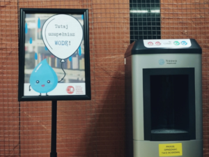 zdjęcie przedstawiające plakat z kroplą wody i dystrybutor wody
